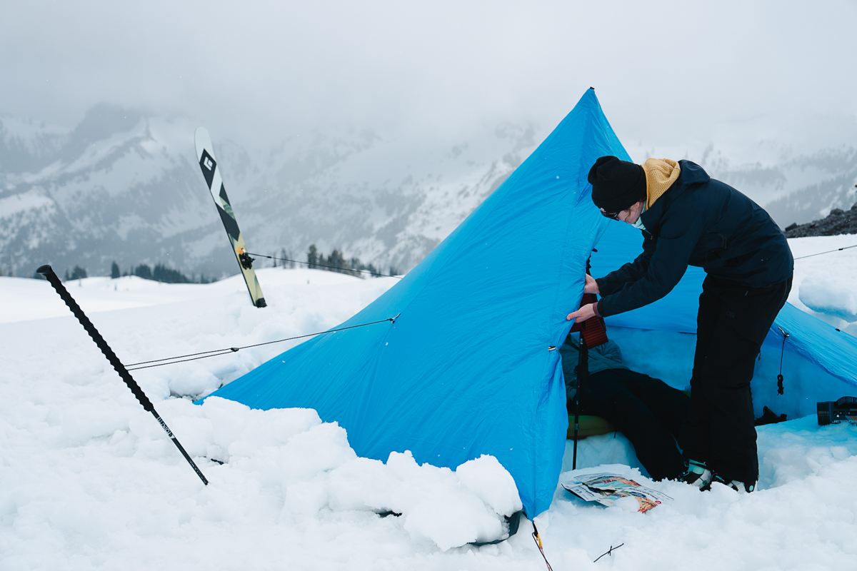 Camping checklist (heading into tent at snowy camp)